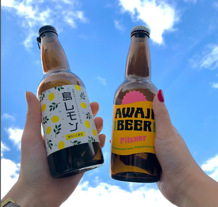 青空を淡路ビール人気のピルスナー、島レモンを掲げた写真
