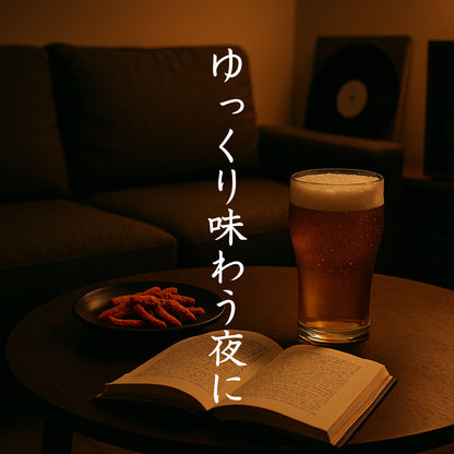 自宅のサイドテーブルにビールと読みかけの本、つまみが置かれ、「ゆっくり味わう夜に」と記載されたイメージ画像
