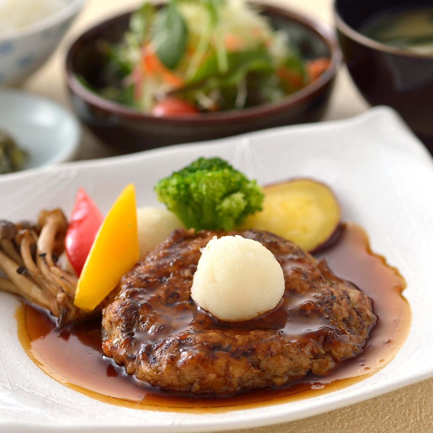 ジューシーなハンバーグを主役に、サラダや味噌汁と彩り豊かな野菜を添えた満足感ある一皿