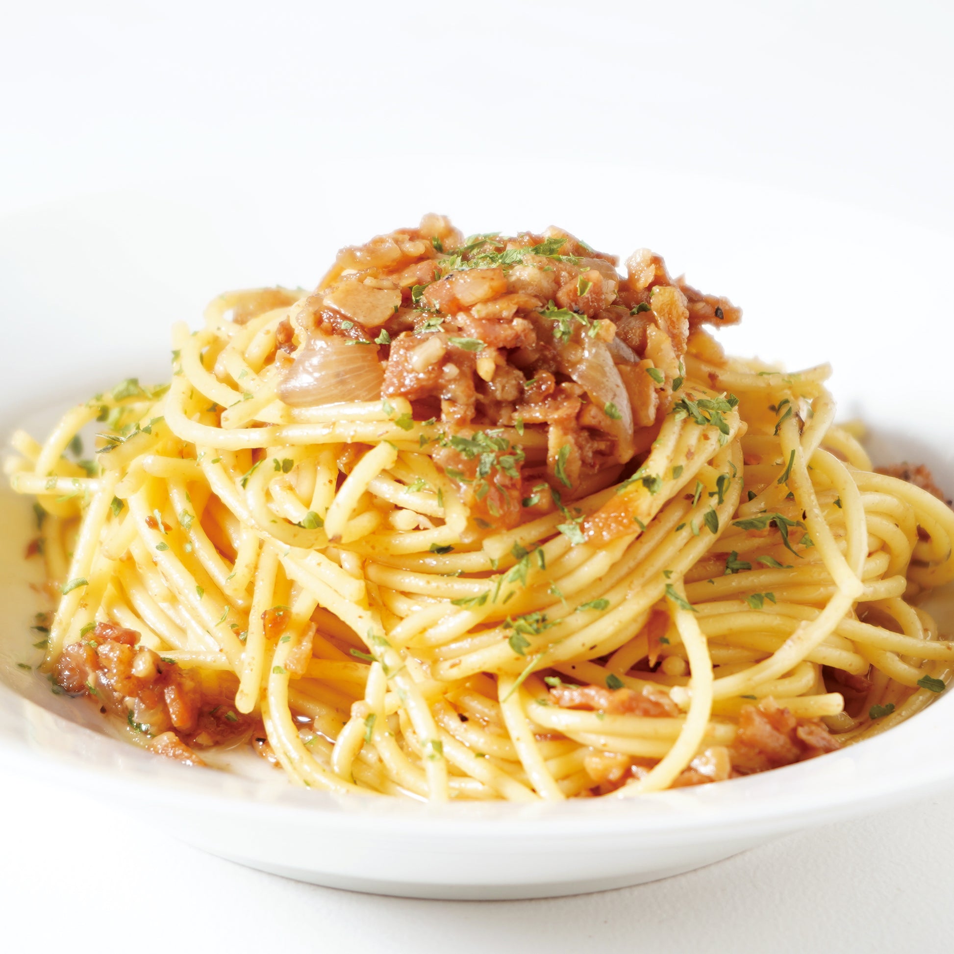 パスタソースを使ったペペロンチーノ、たっぷりの具材がのったパスタをお皿にのせて