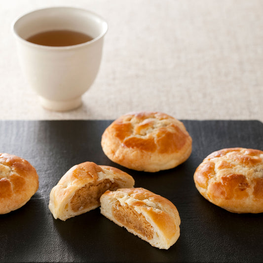 玉ねぎパイが黒のお皿に4つ並べて。洋菓子だけど、今日は日本茶と合わせてみました。